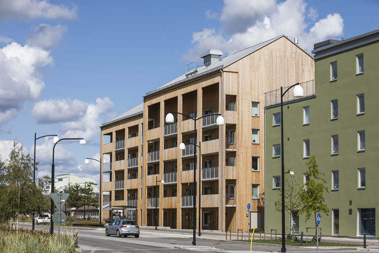 Flerbostadshus med bilväg och busshållplats framför, i Örebro.